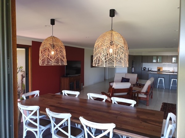 Woven pendant lights above a dining table
