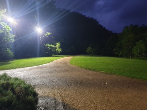 Floodlights lighting a driveway and lawn after dark
