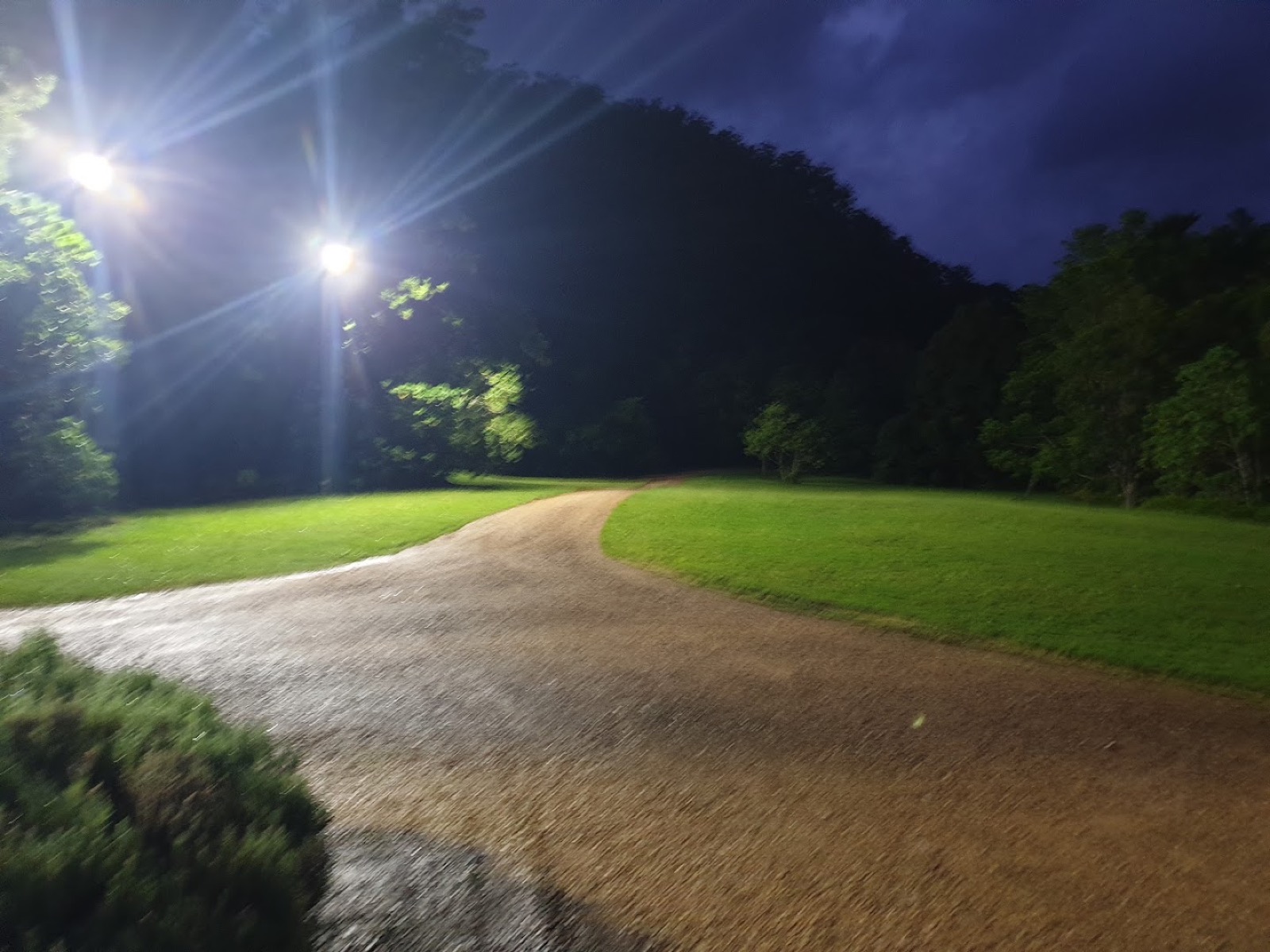 Floodlights lighting a driveway and lawn after dark